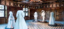 An exhibition of historical white clothing inside a Swiss museum room.