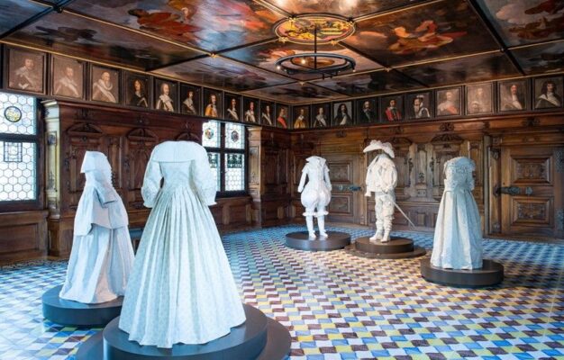 An exhibition of historical white clothing inside a Swiss museum room.